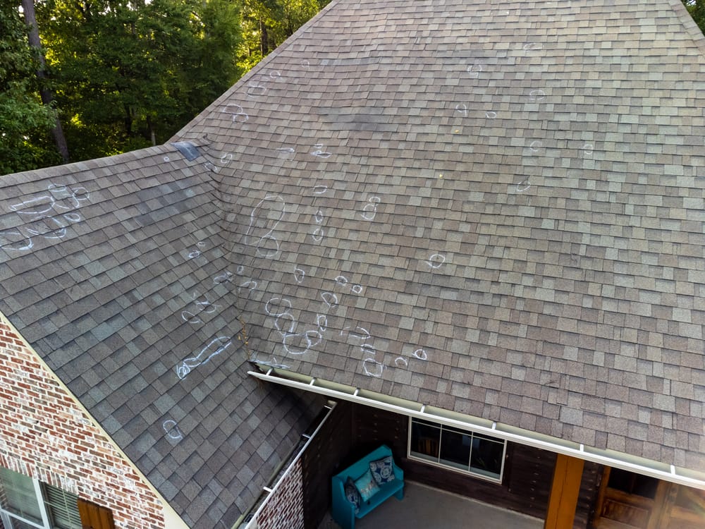 Aerial view of a house roof with multiple chalk markings indicating damage or areas for inspection.